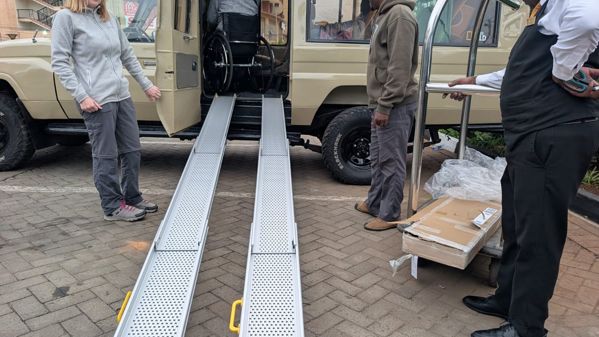 Guest being helped into an accessible vehicle by the Accessible Travel team