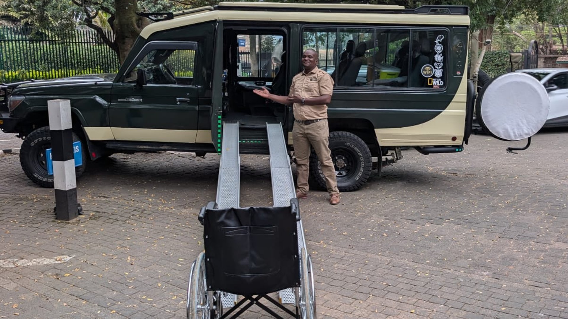 Wheelchair user boarding a safari vehicle using dual-track ramps